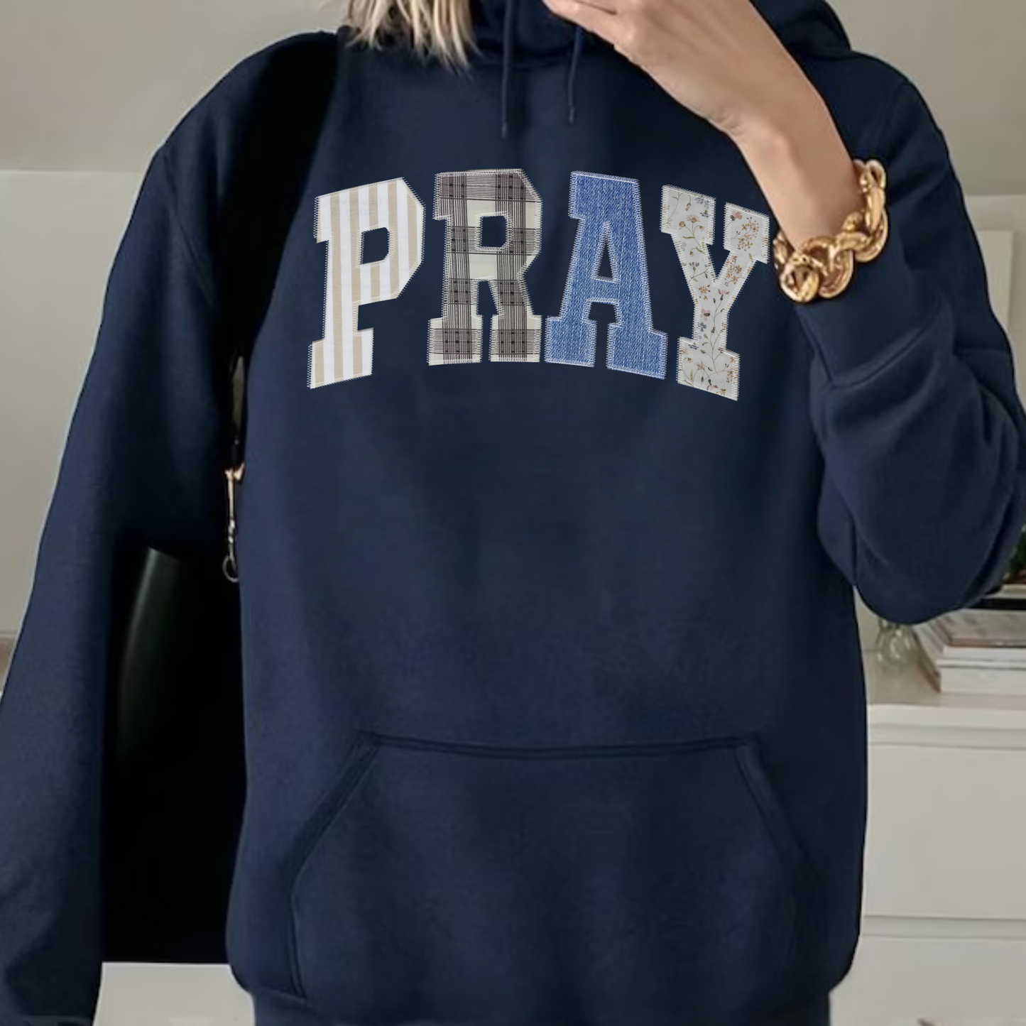 Close-up of PRAY applique lettering with mixed neutral patchwork textures