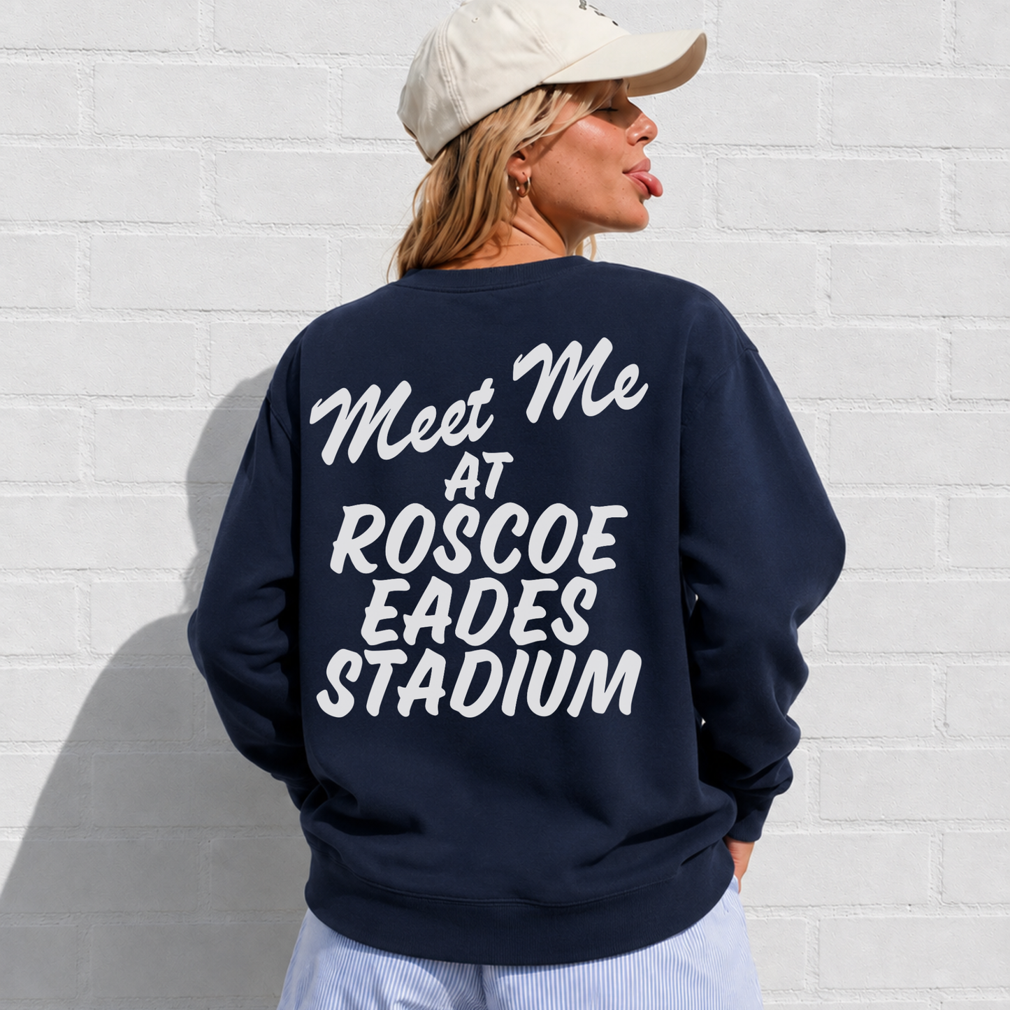 Woman wearing navy Sterling Warriors crewneck sweatshirt with oversized white Meet Me at Roscoe Eades Stadium back graphic.