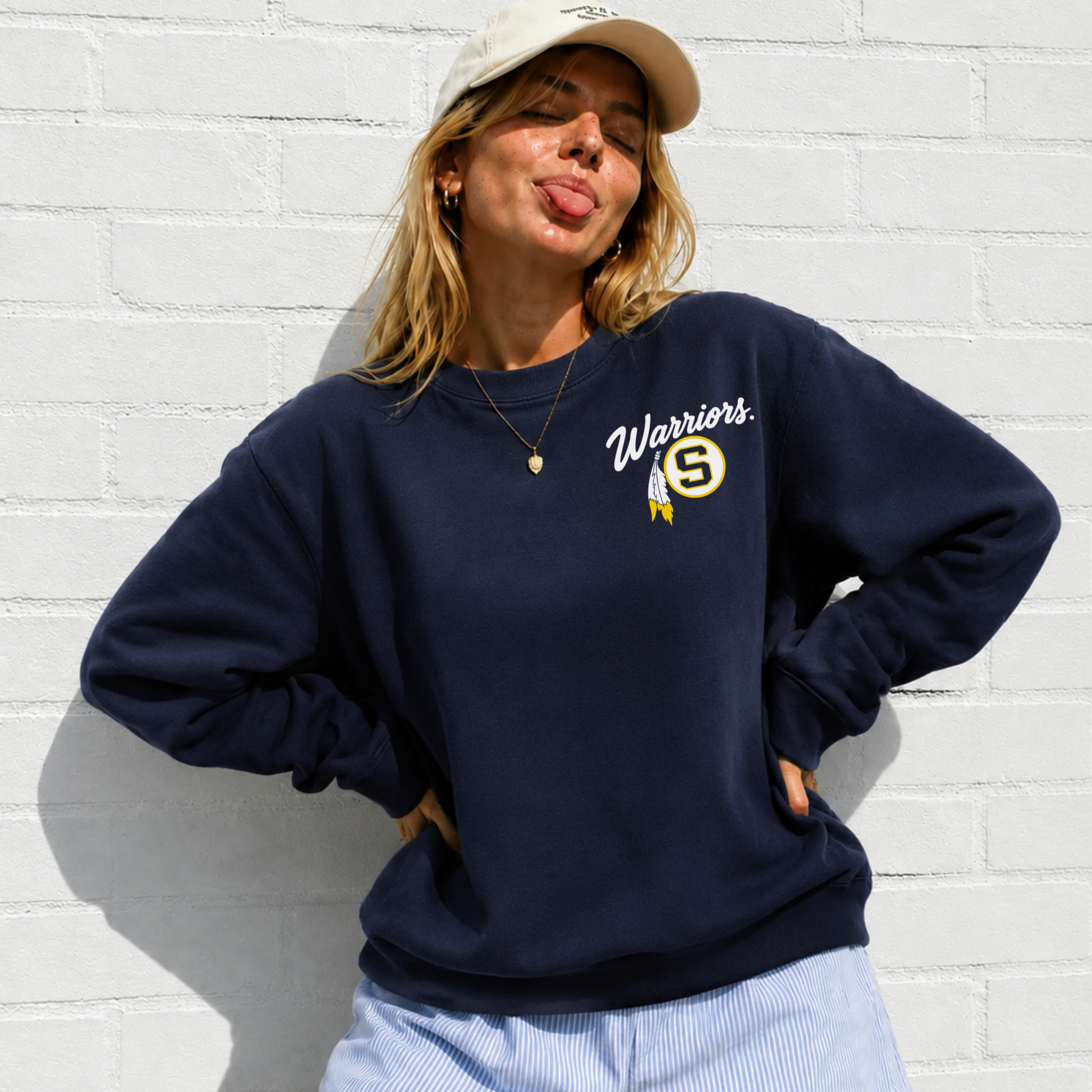 Woman wearing navy Sterling Warriors game day sweatshirt featuring Warriors script, Sterling S logo and gold feather left chest design.