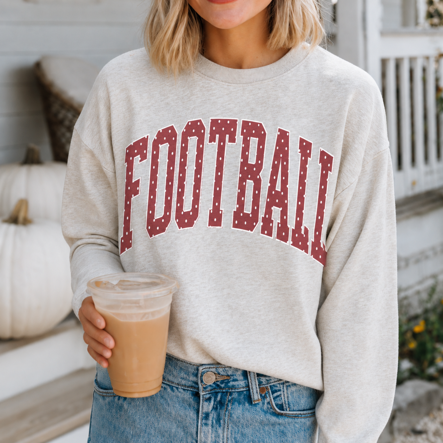 Woman wearing heather grey football sweatshirt with crimson polka dot lettering on game day