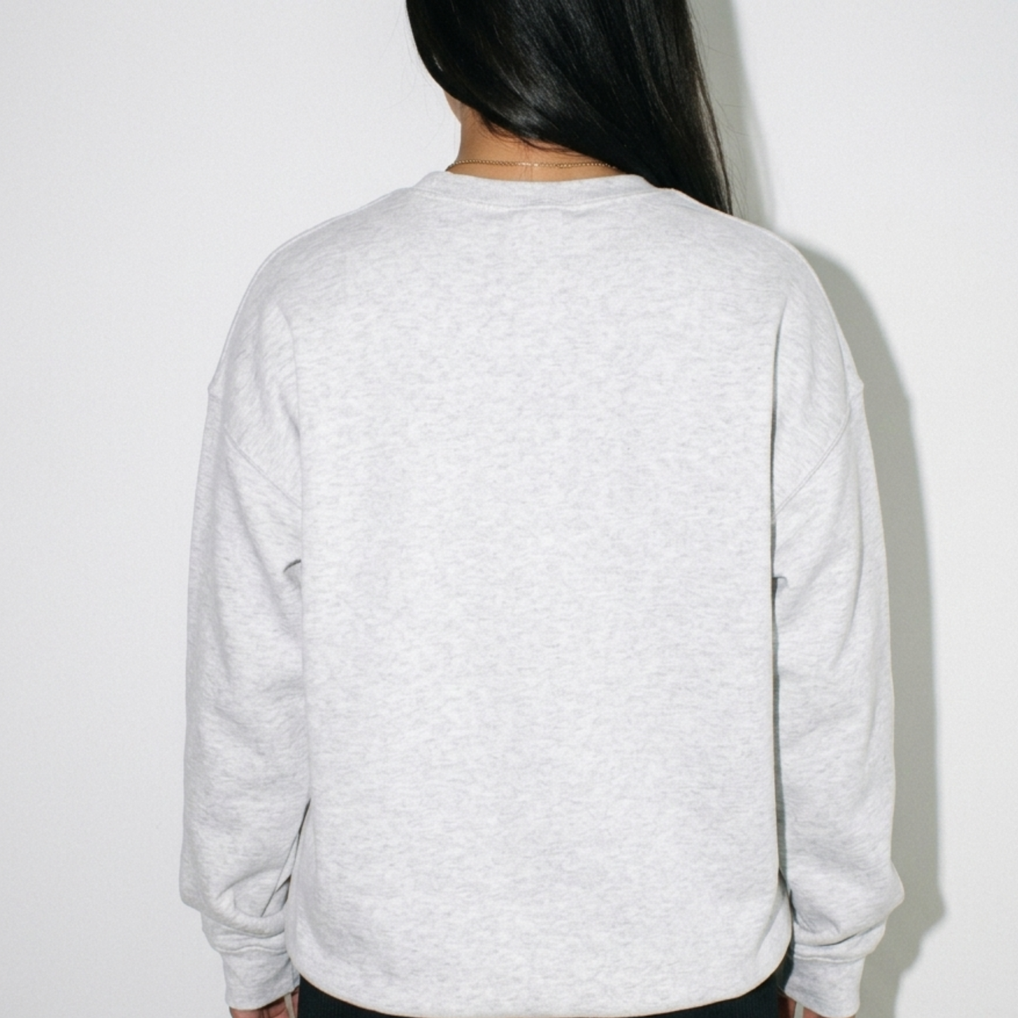 Back view of woman wearing heather gray Jacksonville football crewneck sweatshirt