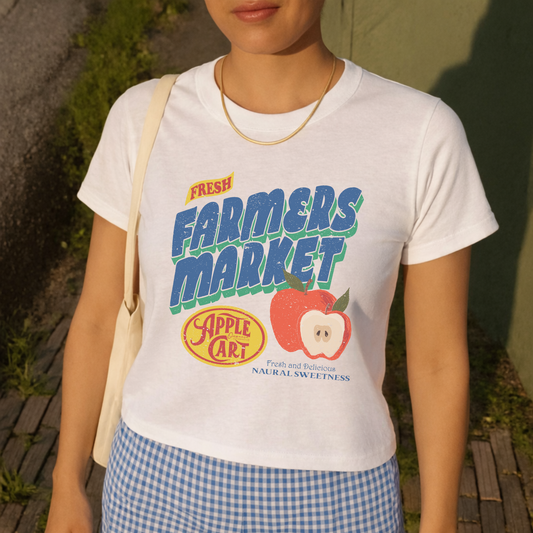 Woman wearing Fresh Farmers Market apple graphic tee styled with gingham skirt for a casual summer outfit