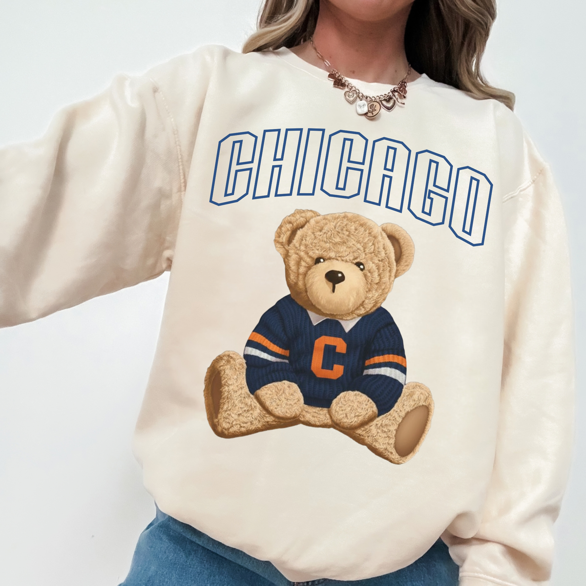 Woman wearing an off-white Chicago vintage teddy bear crewneck sweatshirt with navy varsity lettering and retro football bear graphic