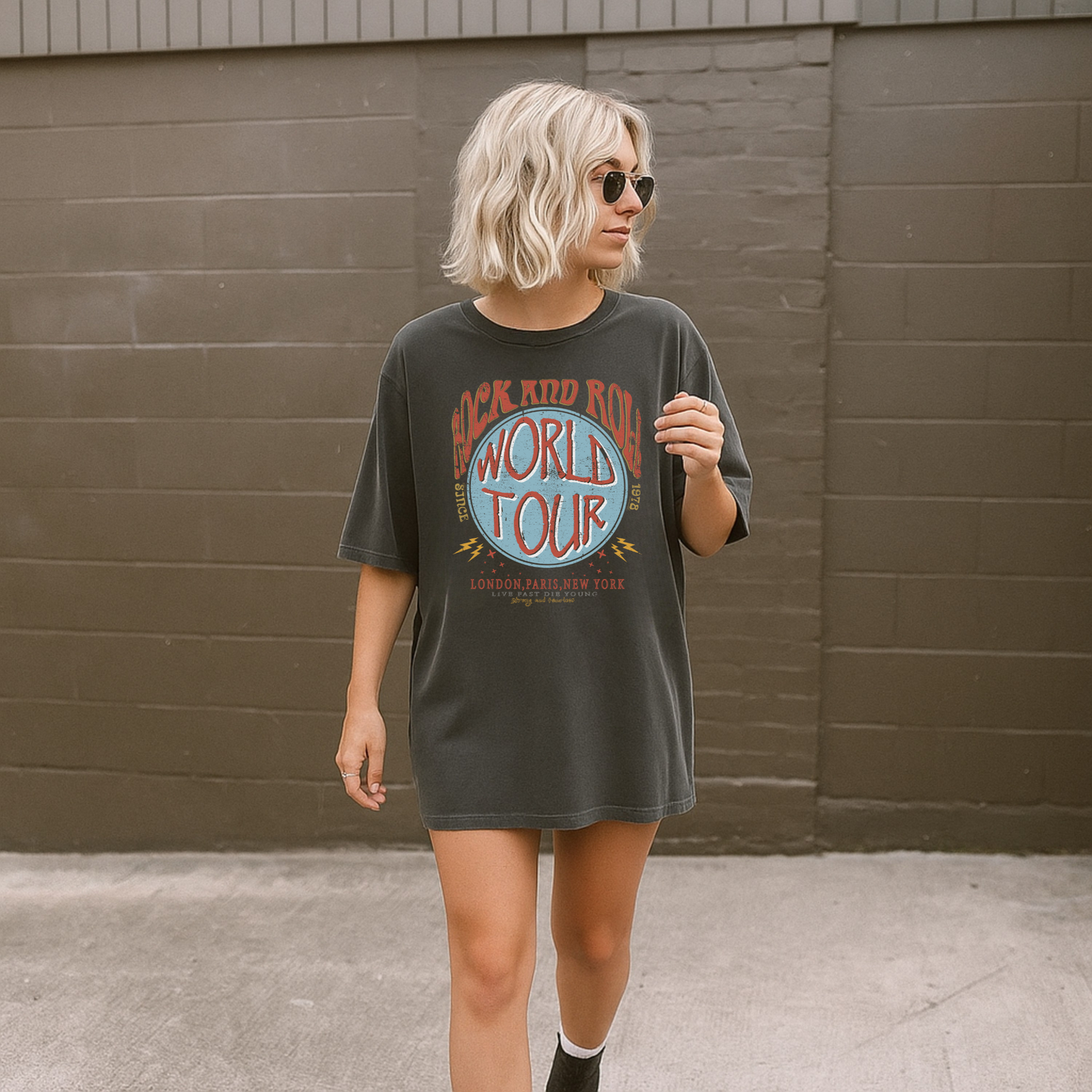 Woman wearing Rock and Roll World Tour graphic t-shirt on Comfort Colors 1717 sized up for a relaxed fit
