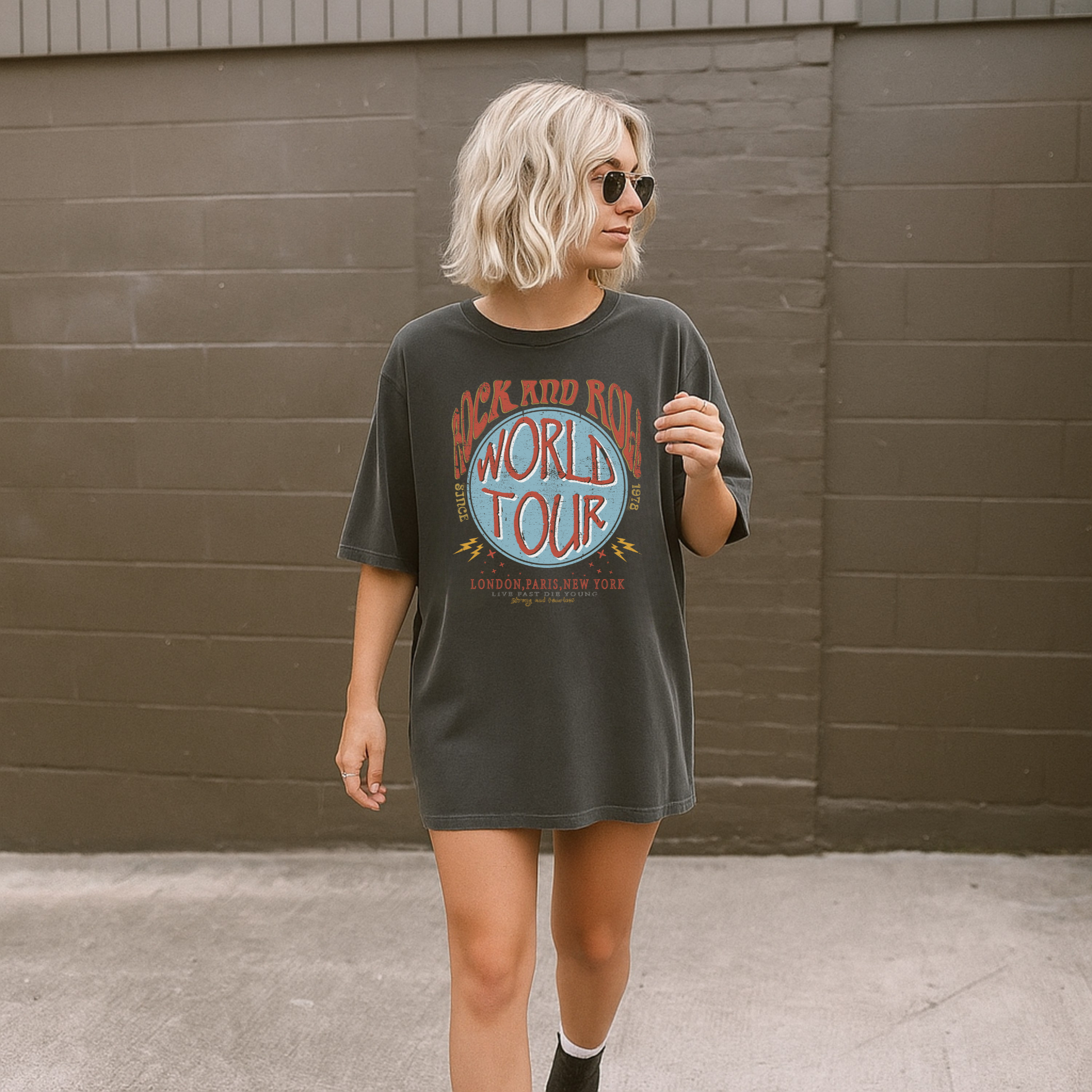 Woman wearing Rock and Roll World Tour graphic t-shirt on Comfort Colors 1717 sized up for a relaxed fit
