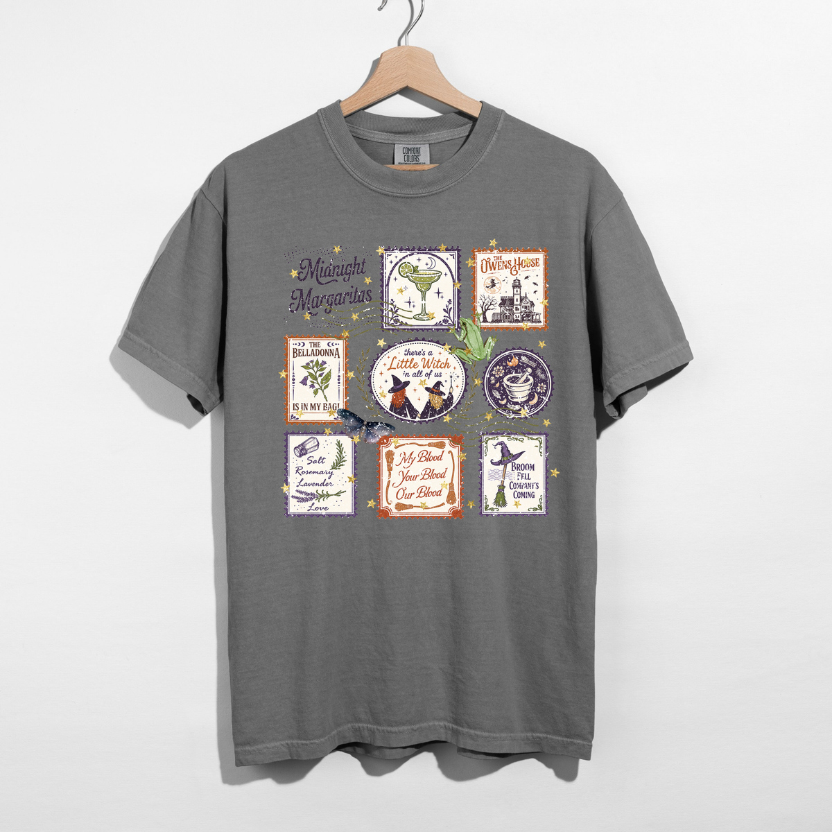 Pepper gray Midnight Margaritas graphic tee with vintage Halloween postage stamp collage featuring witchy quotes, margarita glass, magical herbs, broomsticks, and purple and orange details.