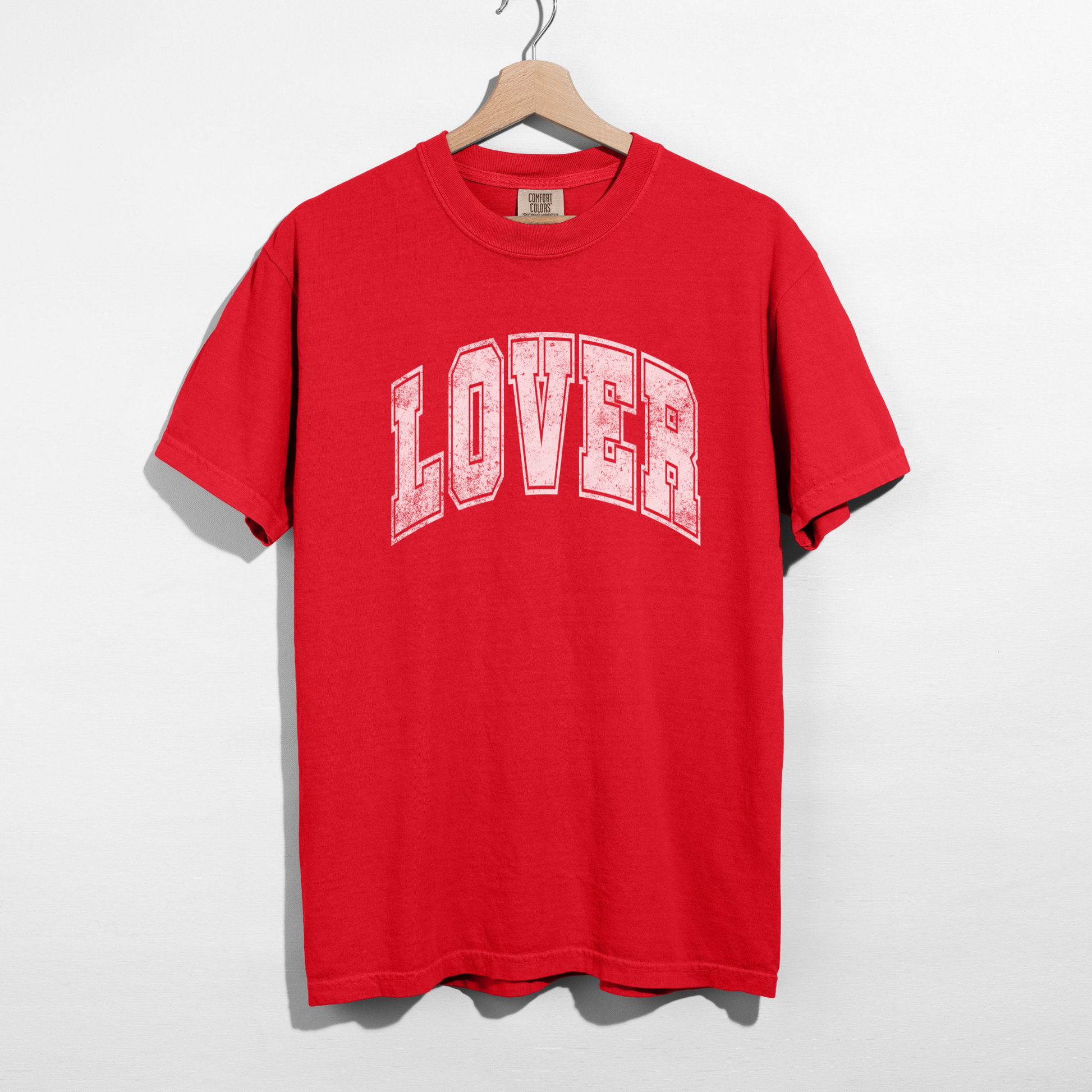 Red LOVER graphic tee hanging on wooden hanger – Valentine’s Day women’s shirt