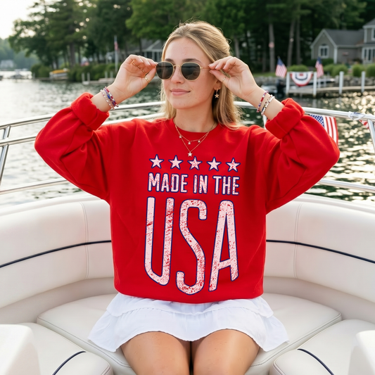 Woman wearing red Made in the USA sweatshirt on a boat with sunglasses patriotic summer outfit
