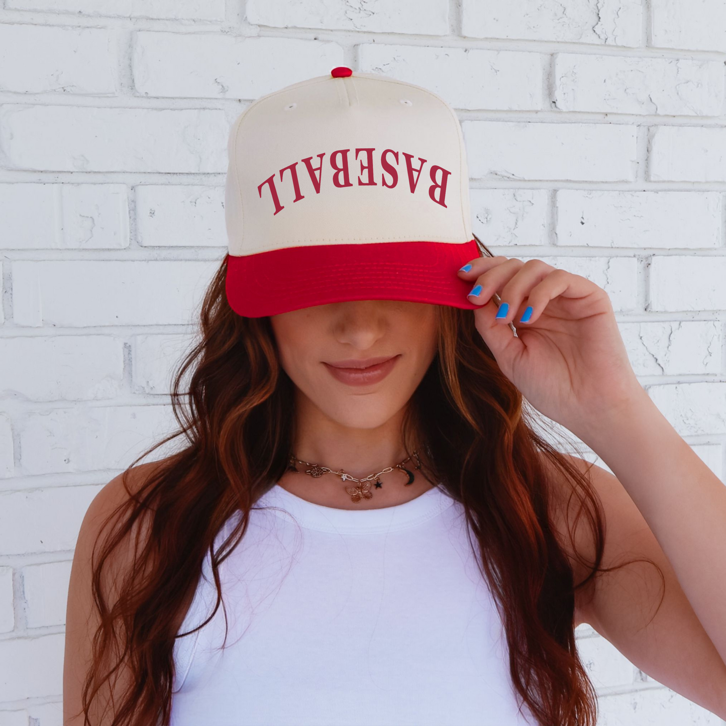 A person wearing a white and red trucker hat with the text 'BASEBALL' on the front.