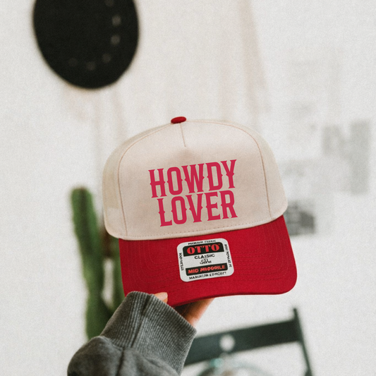 “Howdy Lover red and canvas western trucker hat lifestyle photo held in hand”