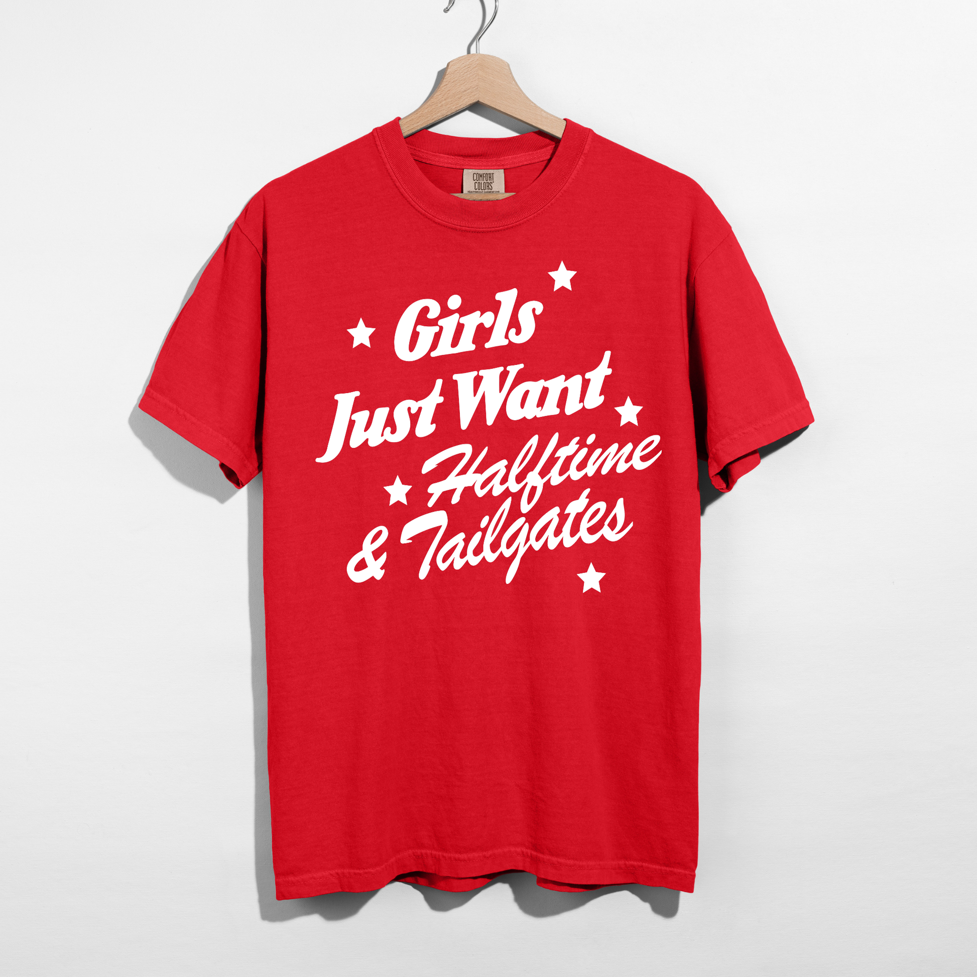Red garment-dyed football game day graphic tee featuring the phrase "Girls Just Want Halftime & Tailgates" in bold white lettering.