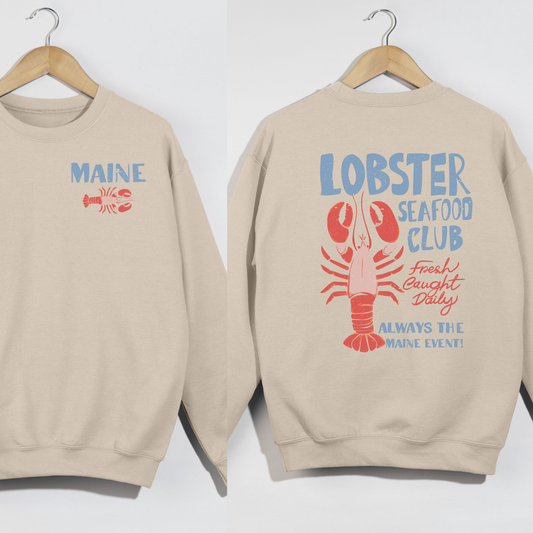 Beige sweatshirt with 'MAINE' and lobster graphic on a white background