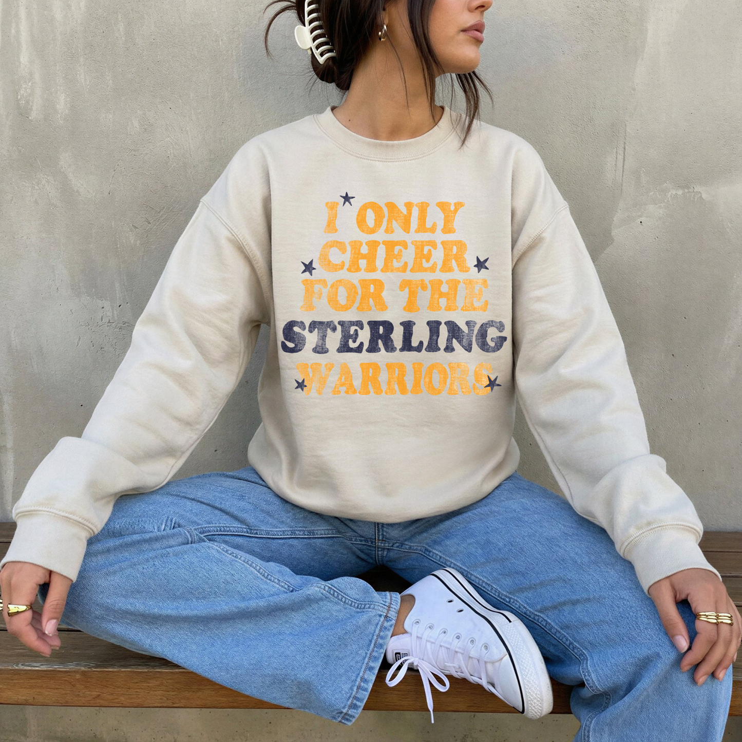 i only cheer for the sterling warriors sweatshirt worn by woman sitting in casual jeans outfit game day sports mom style