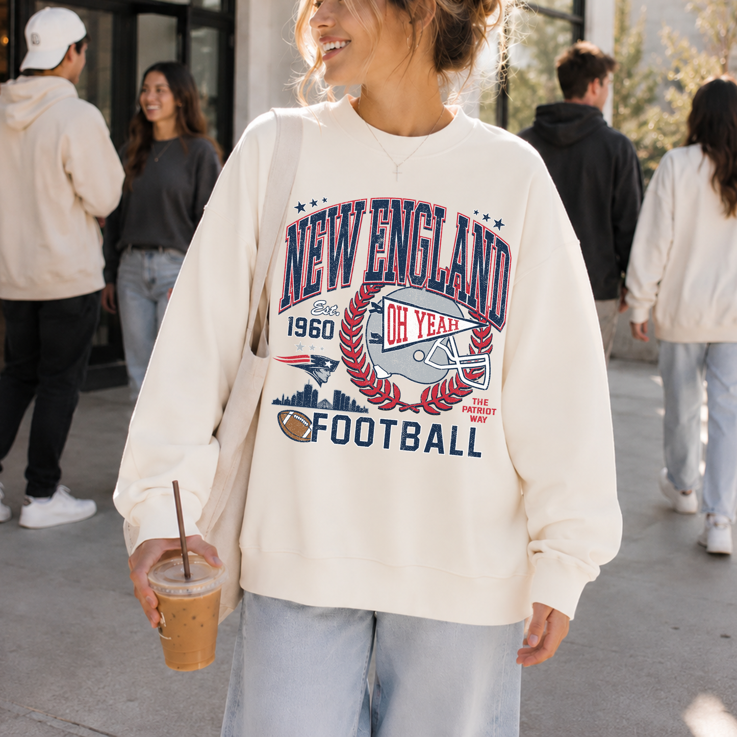Woman wearing cream New England football sweatshirt with vintage navy and red game day graphic