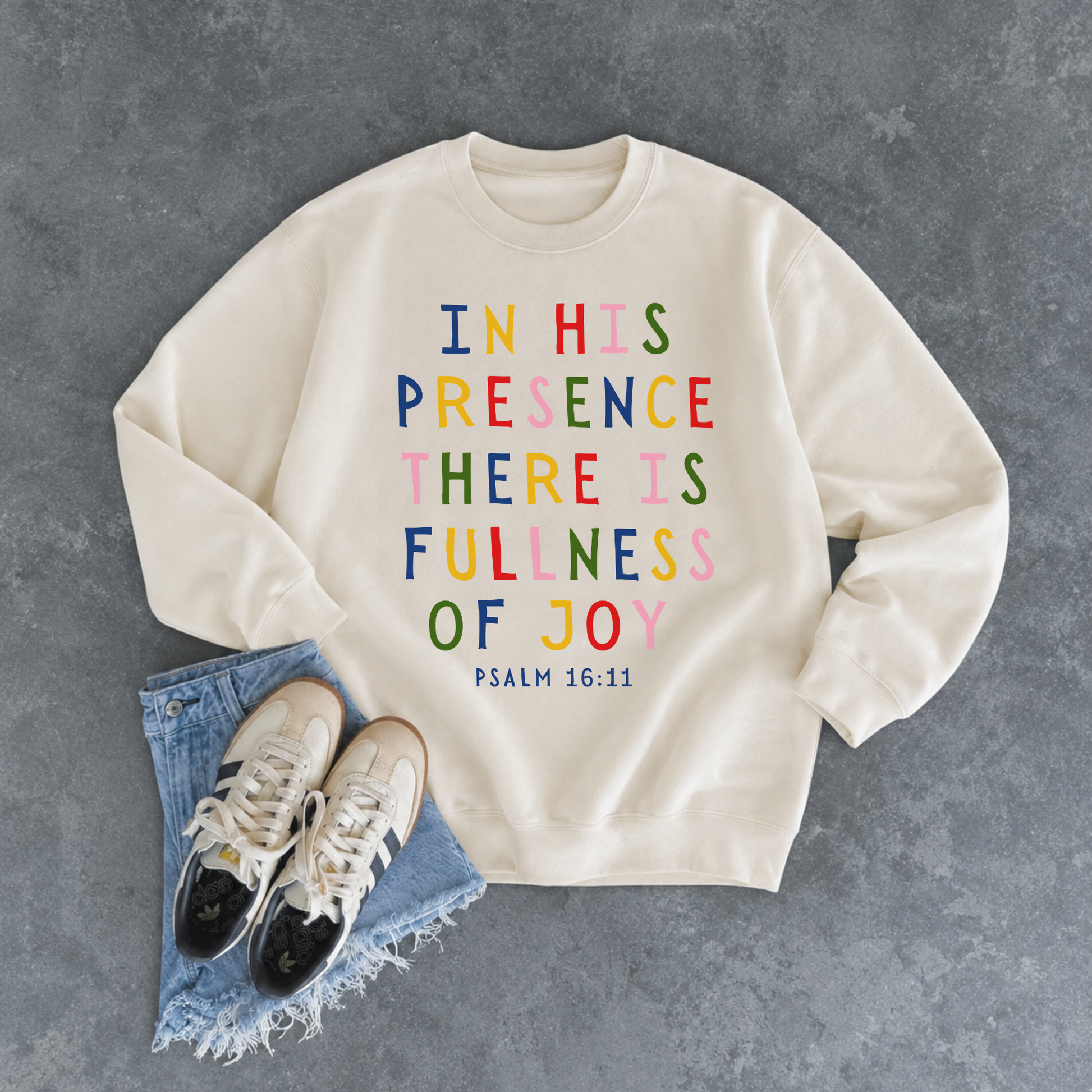 Natural sand crewneck sweatshirt displaying the colorful Christian Bible verse "In His Presence There Is Fullness of Joy" from Psalm 16:11.