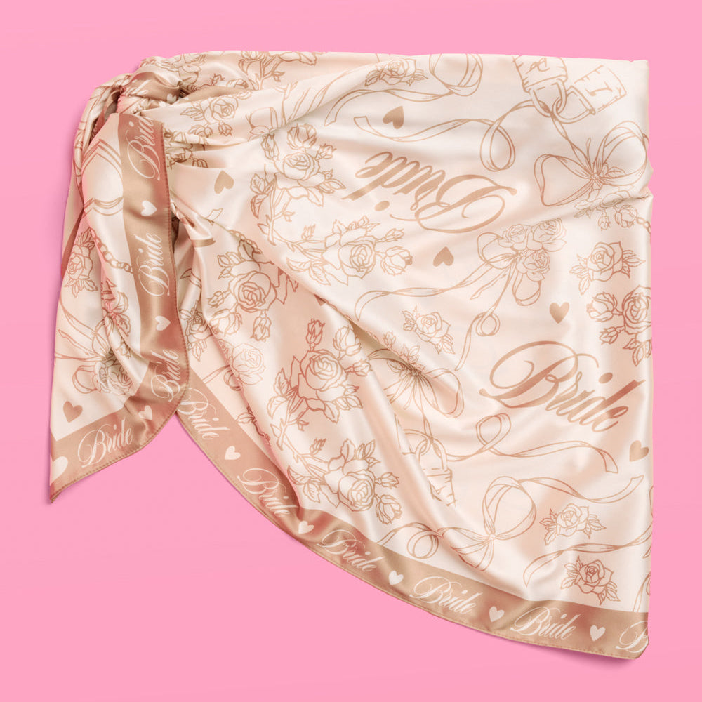 Decorative headscarf with floral and paisley patterns on a pink background