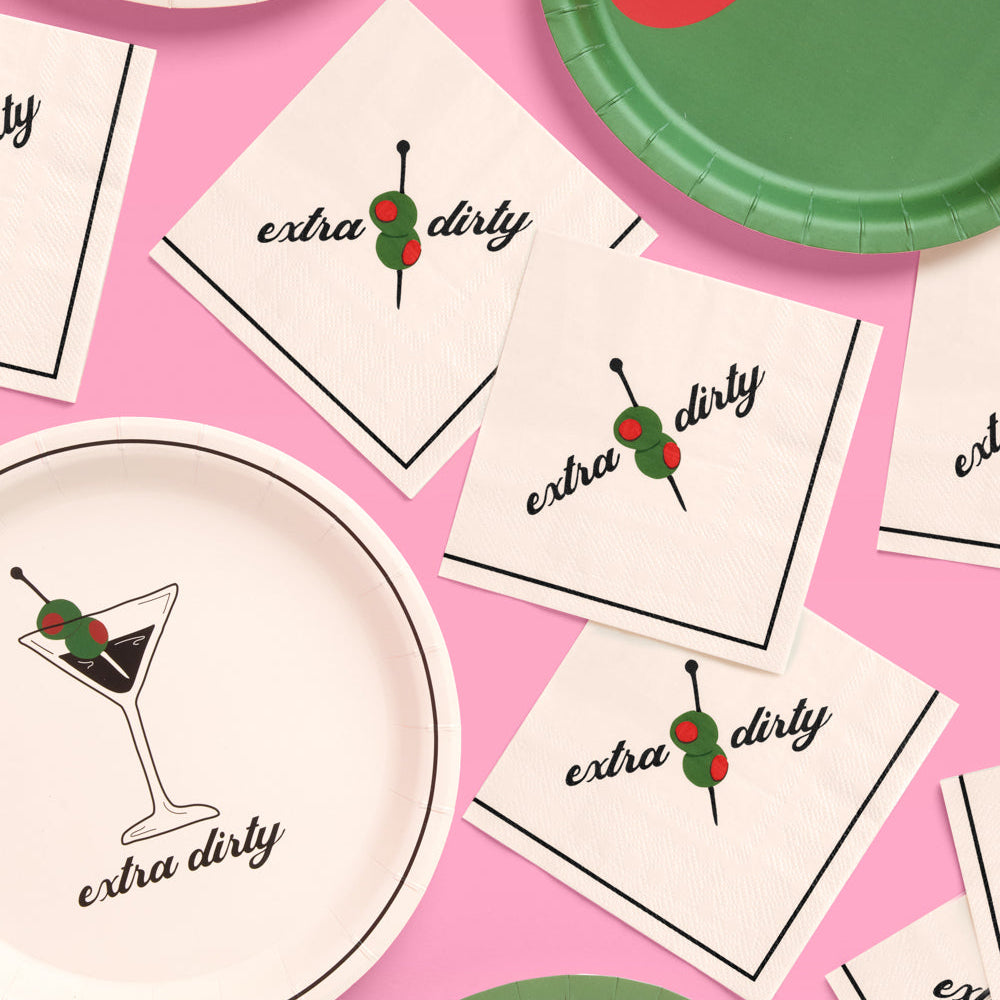Party supplies including plates and napkins with 'extra dirty' text and cocktail graphics on a pink background.