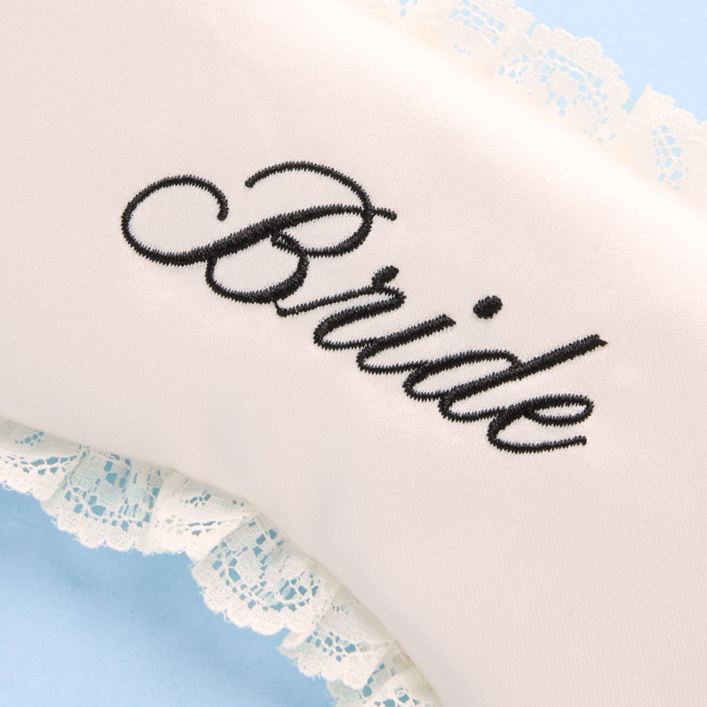 White sleep mask with 'Bride' embroidery on a light blue background