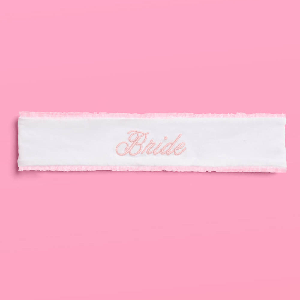 White headband with 'Bride' embroidery on a pink background