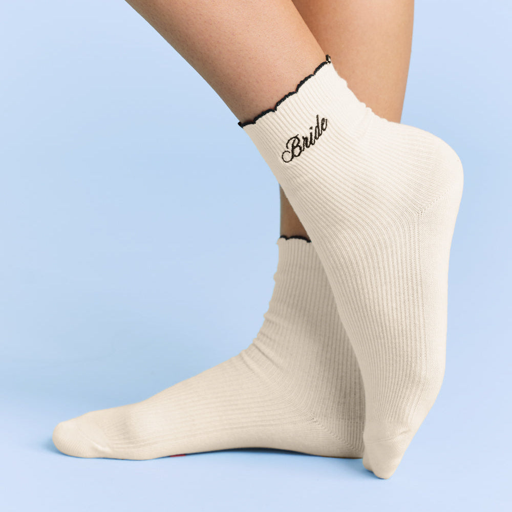 Beige socks with 'Bride' text on a light blue background