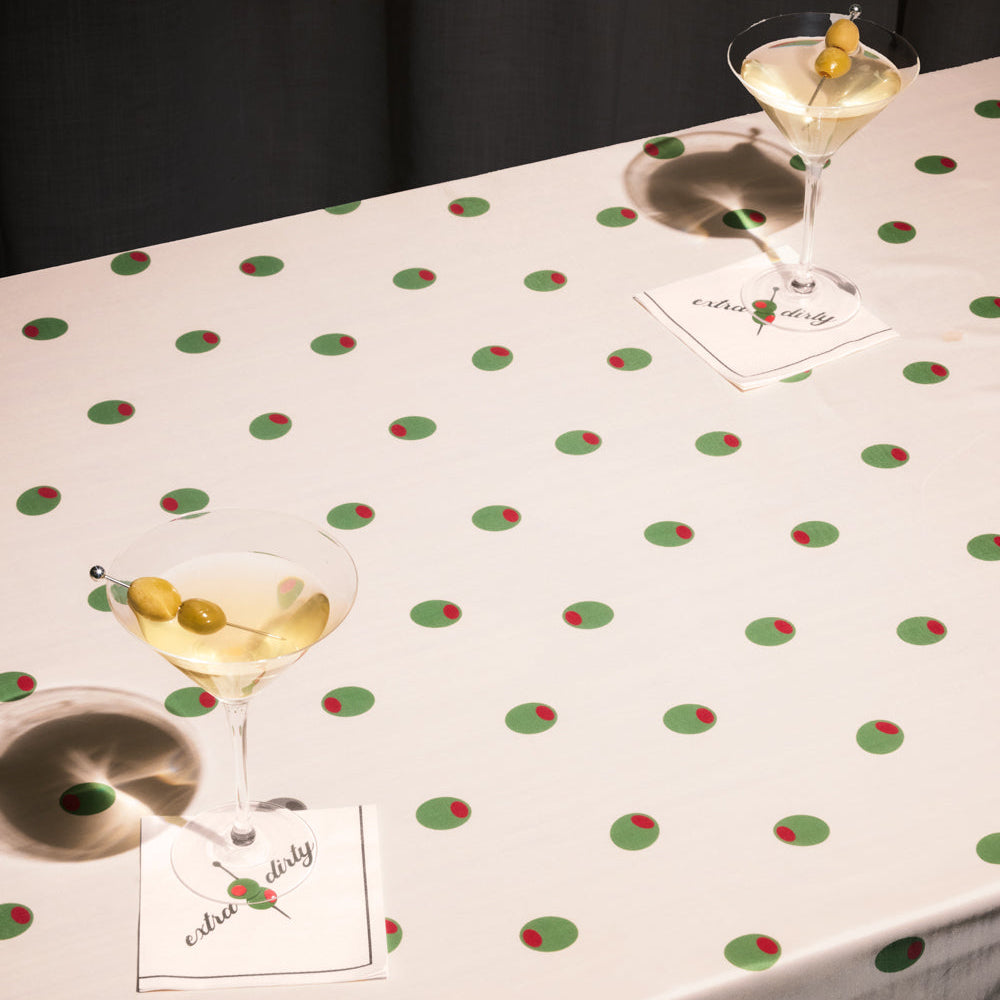 Tablecloth with polka dot pattern and glasses of martini on a dark background