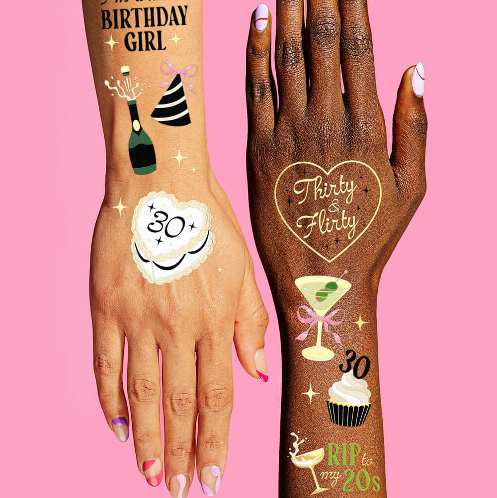 Two hands with temporary tattoos on a pink background
