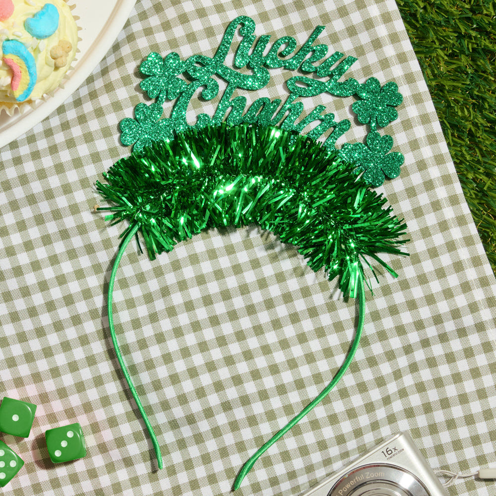 Green festive headband with 'Lucky' text on a checkered tablecloth with cupcakes and dice.