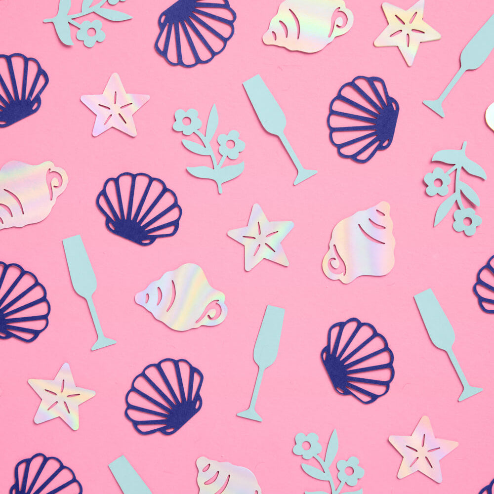 Iridescent sea-themed decorations on a pink background