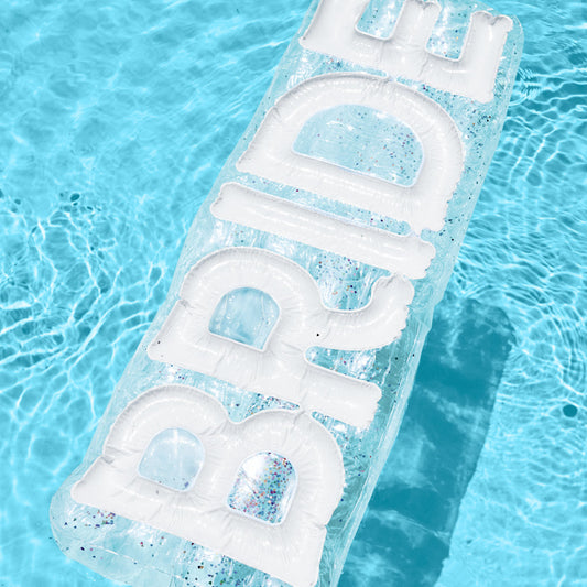 Clear inflatable pool float with 'BRIDE' text floating on water