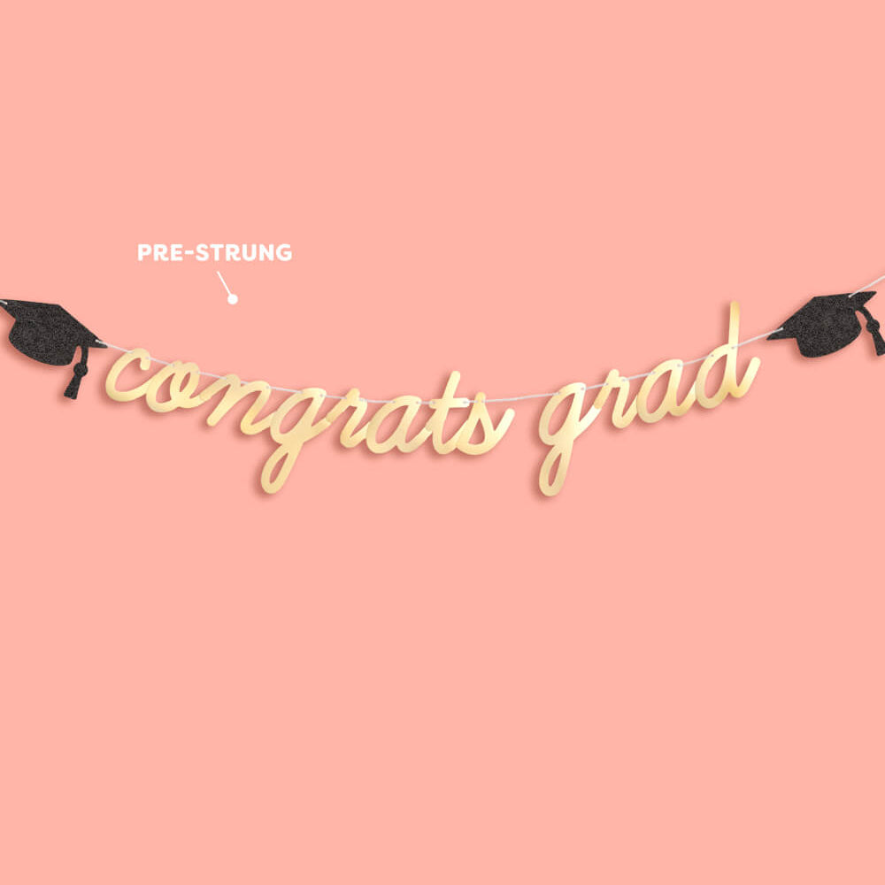 Decorative string with 'congrats grad' text and graduation caps on a pink background