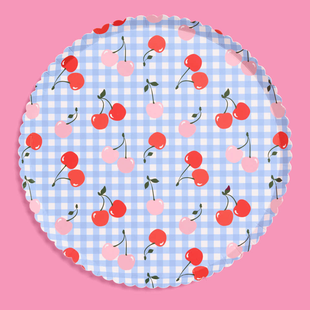 Round paper plate with cherry pattern on a pink background