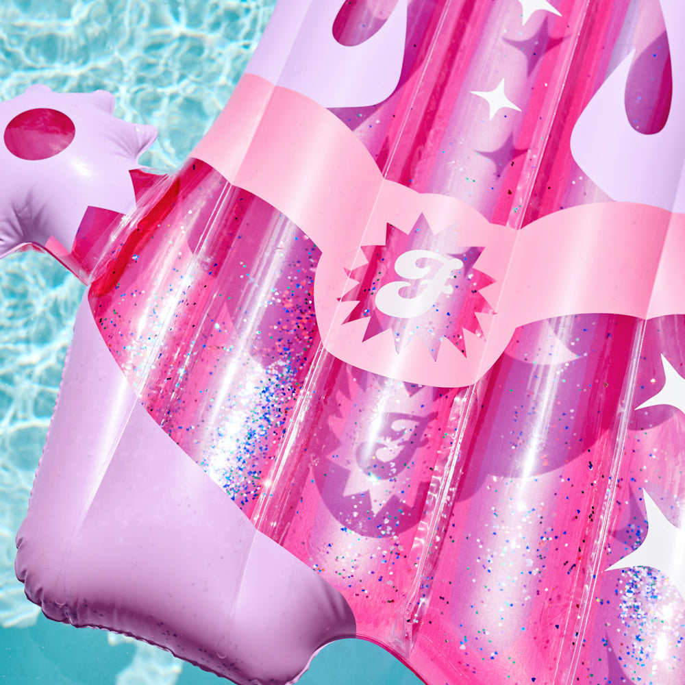 Pink inflatable pool float with star patterns on a blue water background