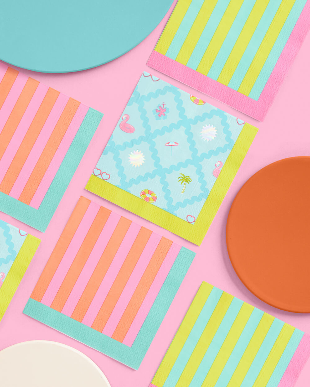 Colorful paper plates with geometric patterns on a pink background