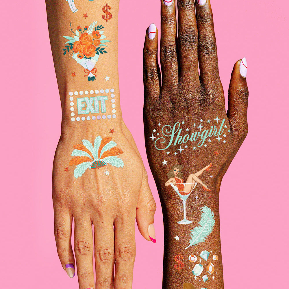 Two hands with colorful temporary tattoos on a pink background