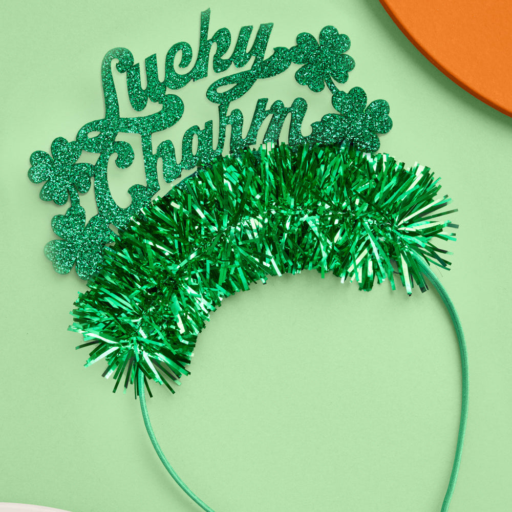 Green tinsel headband with 'Lucky Charm' text on a light green background