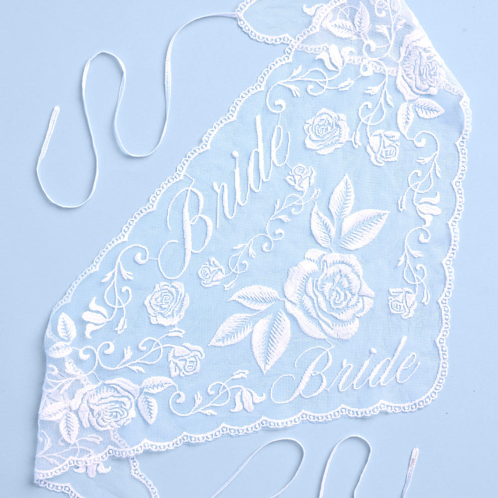 Lace headband with 'Bride' text and floral design on a light blue background