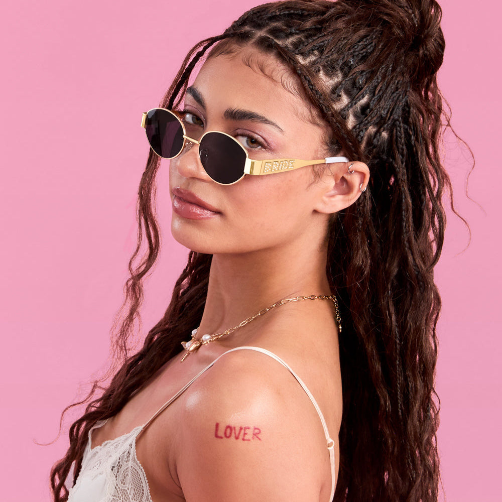 Woman wearing sunglasses with a pink background