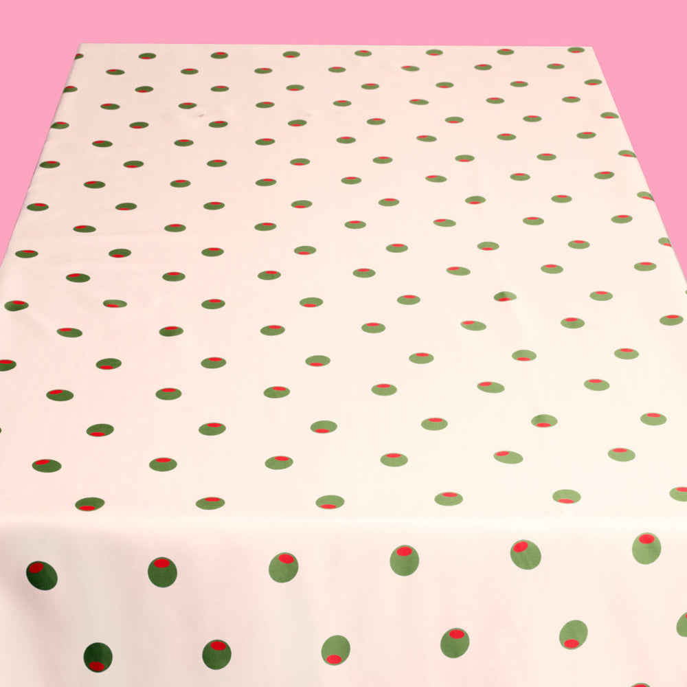 Fabric with red and green polka dot pattern on a pink background
