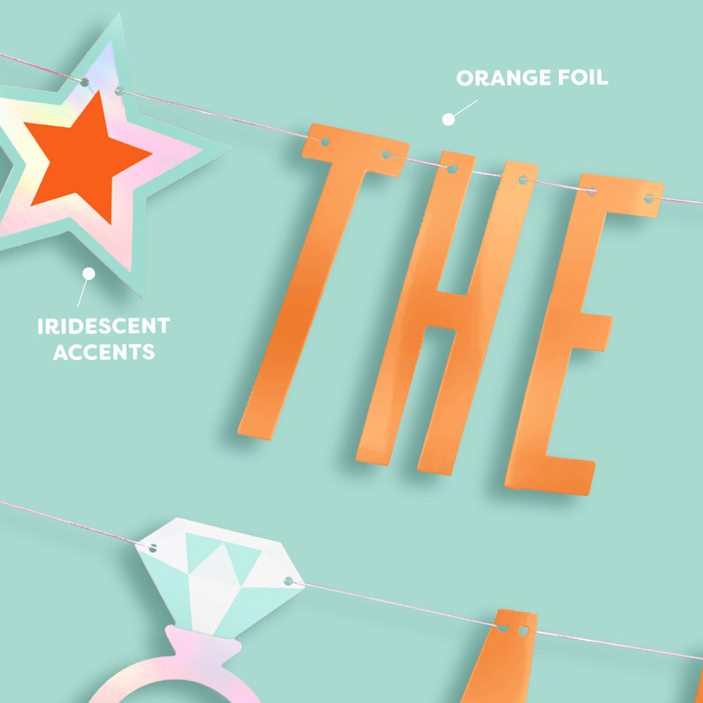 Decorative banner with orange foil letters spelling 'THE' and iridescent accents on a light blue background.