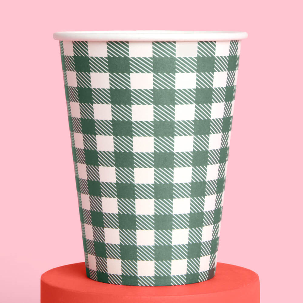 Green and white checkered paper cup on a pink background