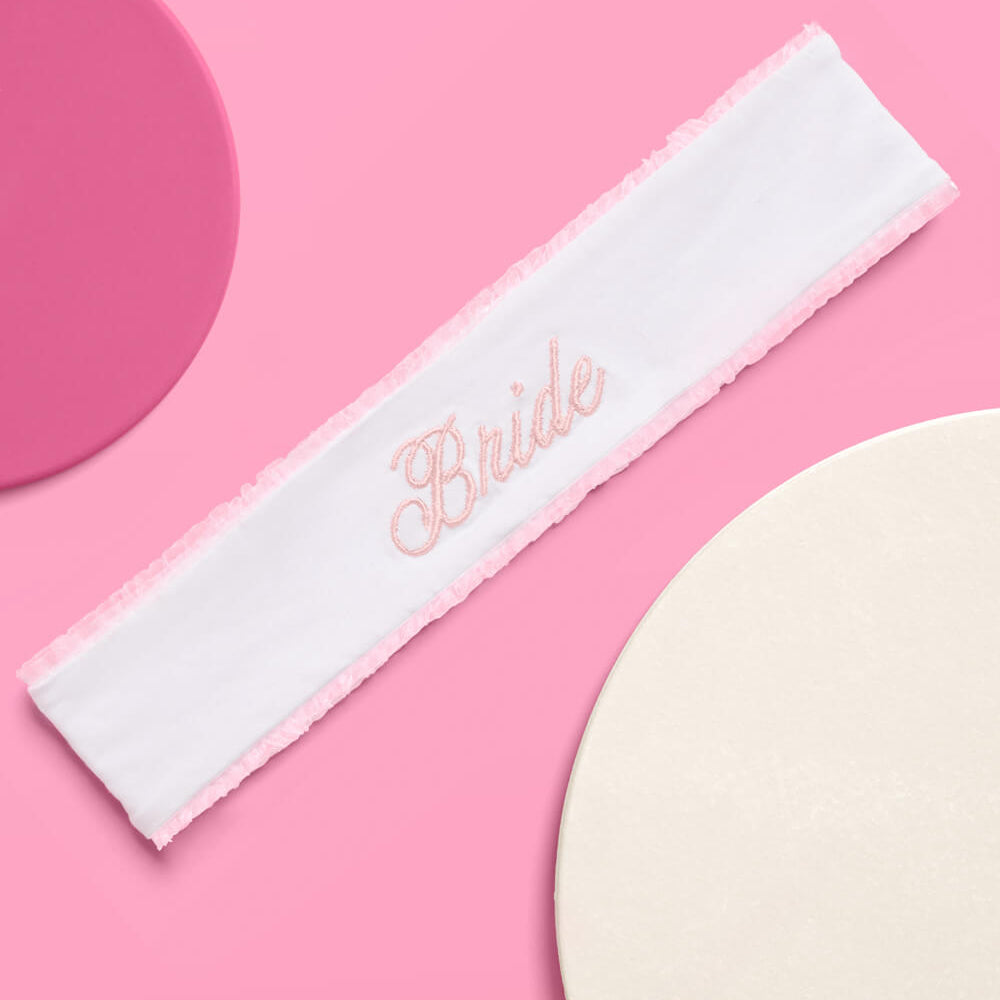 White headband with 'Bride' embroidery on a pink background