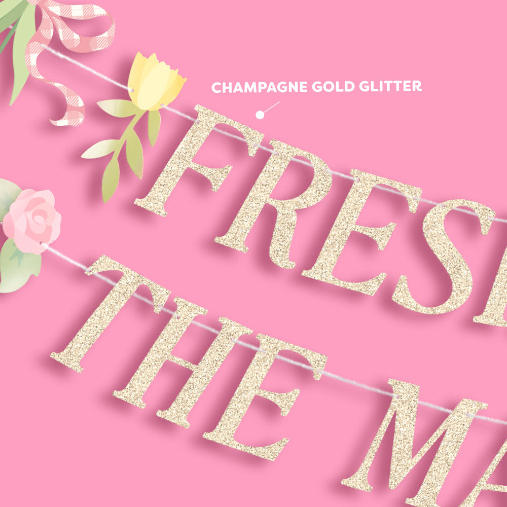 Gold glitter 'Fresh The M...' banner with floral decorations on a pink background