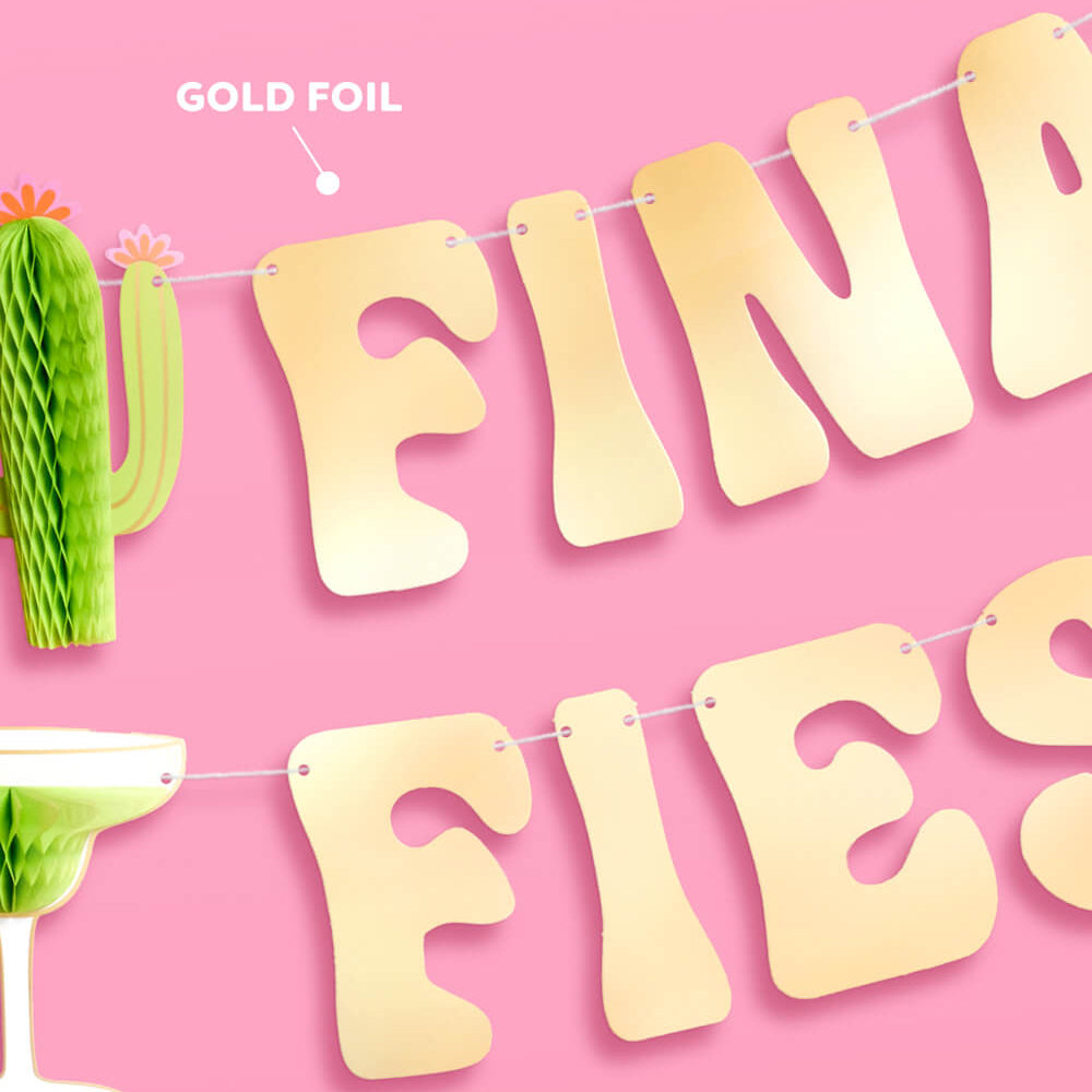 Gold foil 'FINALE FIESTA' banner with cactus and margarita decorations on a pink background