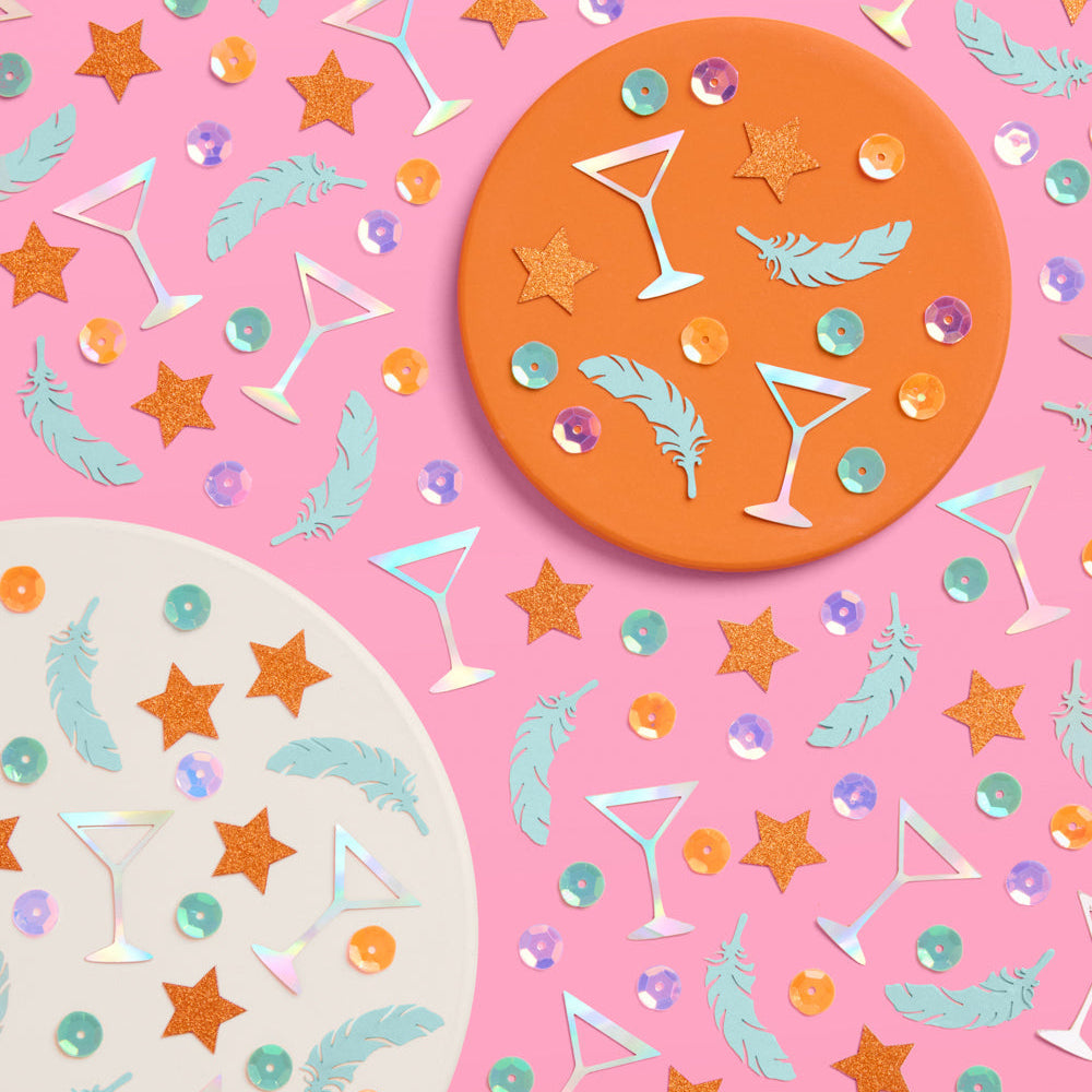 Decorative paper with star, feather, and martini glass patterns on a pink background