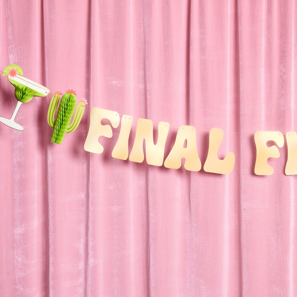 Gold 'FINAL FE' letters on a pink curtain background