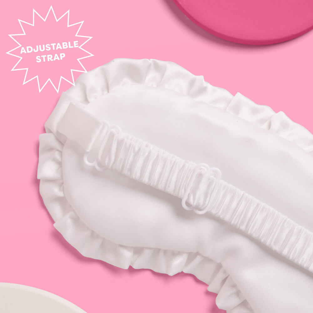 White eye mask with ruffled edges on a pink background