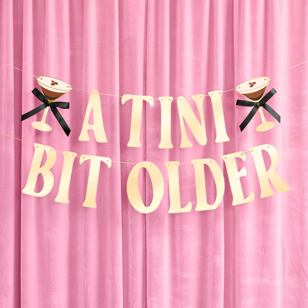 Decorative banner with 'A TINI BIT OLDER' text on a pink background