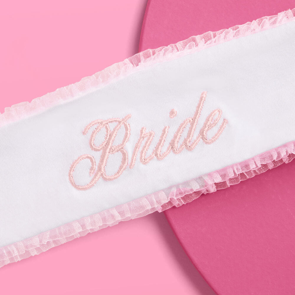 White sash with 'Bride' embroidery on a pink background