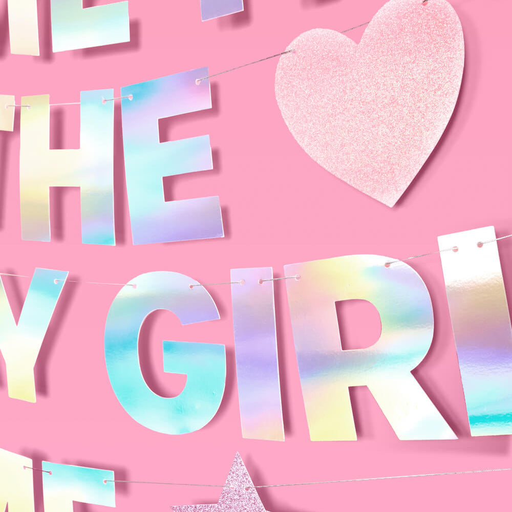 Holographic letter banner with 'HEART THE GIRL ME' on a pink background