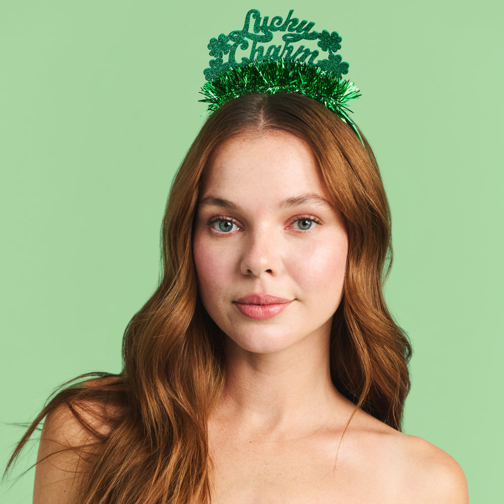 Woman wearing a green St. Patrick's Day headband with shamrock design on a light green background